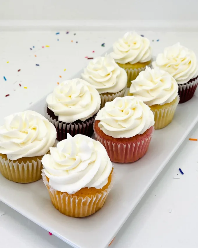 Assorted cupcakes and case desserts with swirled buttercream