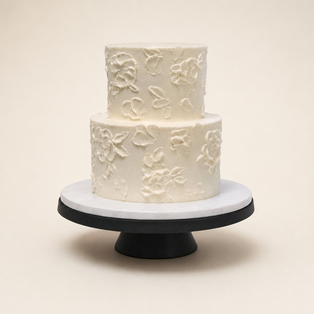 A simple wedding cake with white-on-white palette knife flowers on a marble stand by Sweet Escape Cake Company in Indianapolis.