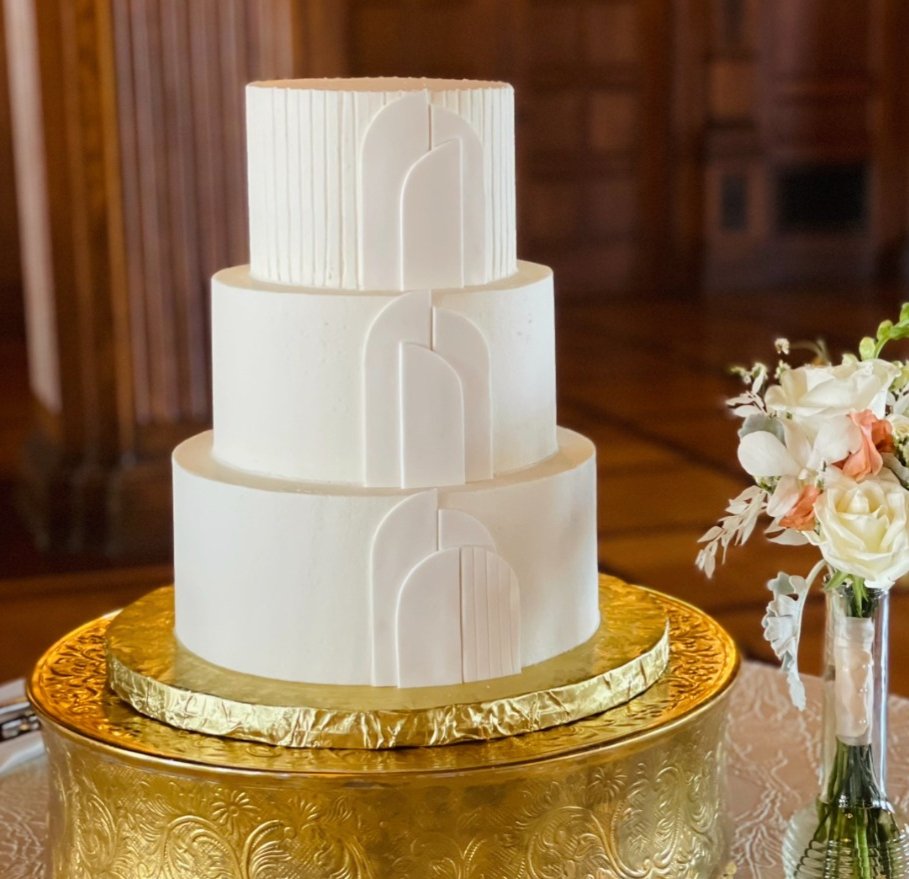 A three-tier white buttercream wedding cake with gold accents by Sweet Escape Cake Company in Indianapolis.