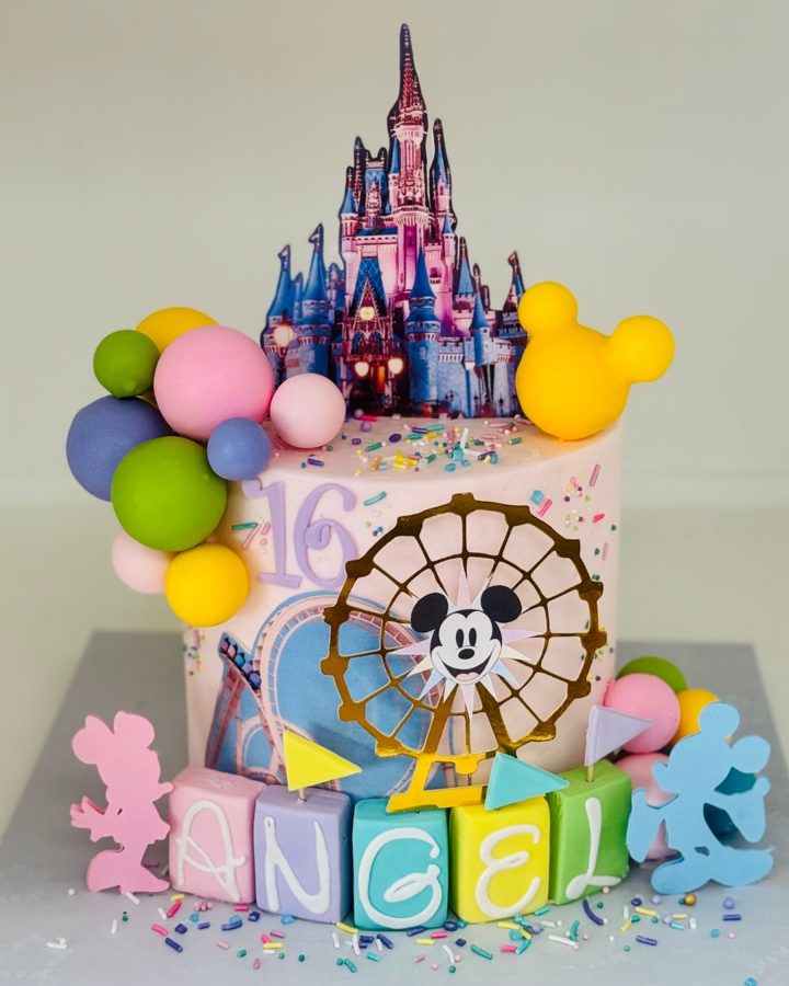A pastel Disney-themed 16th birthday cake featuring a Cinderella castle edible image, a Mickey Mouse Ferris wheel topper, colorful fondant b