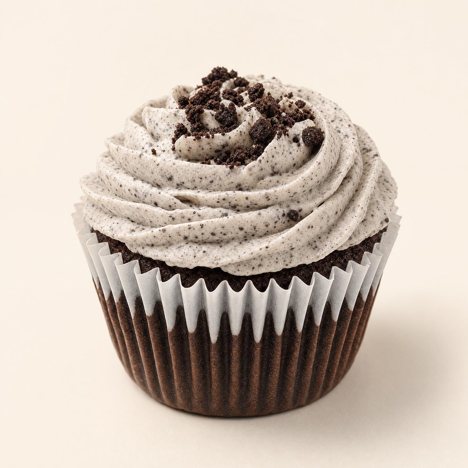 Two decadent chocolate cupcakes topped with creamy cookies and cream frosting and cookie crumb sprinkles, elegantly displayed on a gold dess
