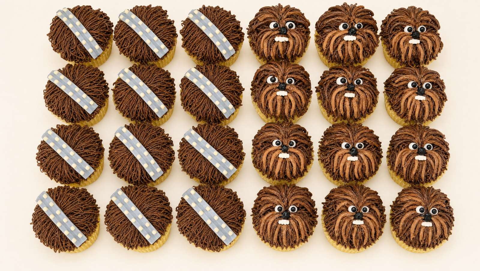 A collection of Star Wars Chewbacca-themed cupcakes, adorned with intricate brown piped buttercream fur, edible eyes, and some featuring gra