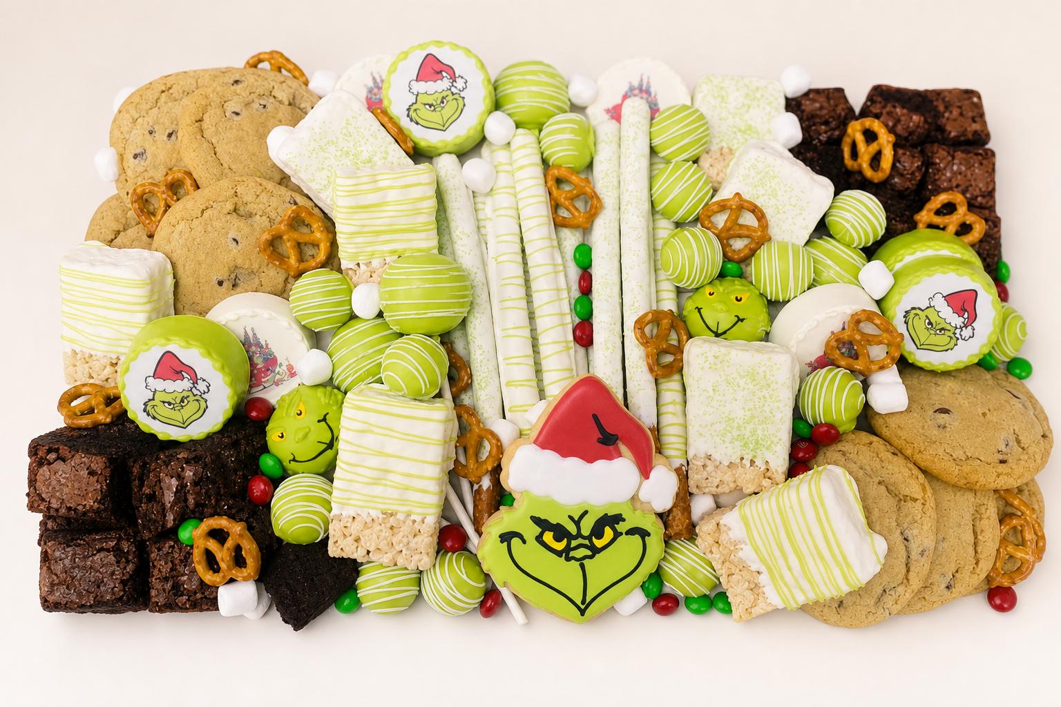A festive Grinch-themed dessert bar featuring a variety of treats including chocolate chip cookies, brownies, chocolate-covered pretzels, Gr