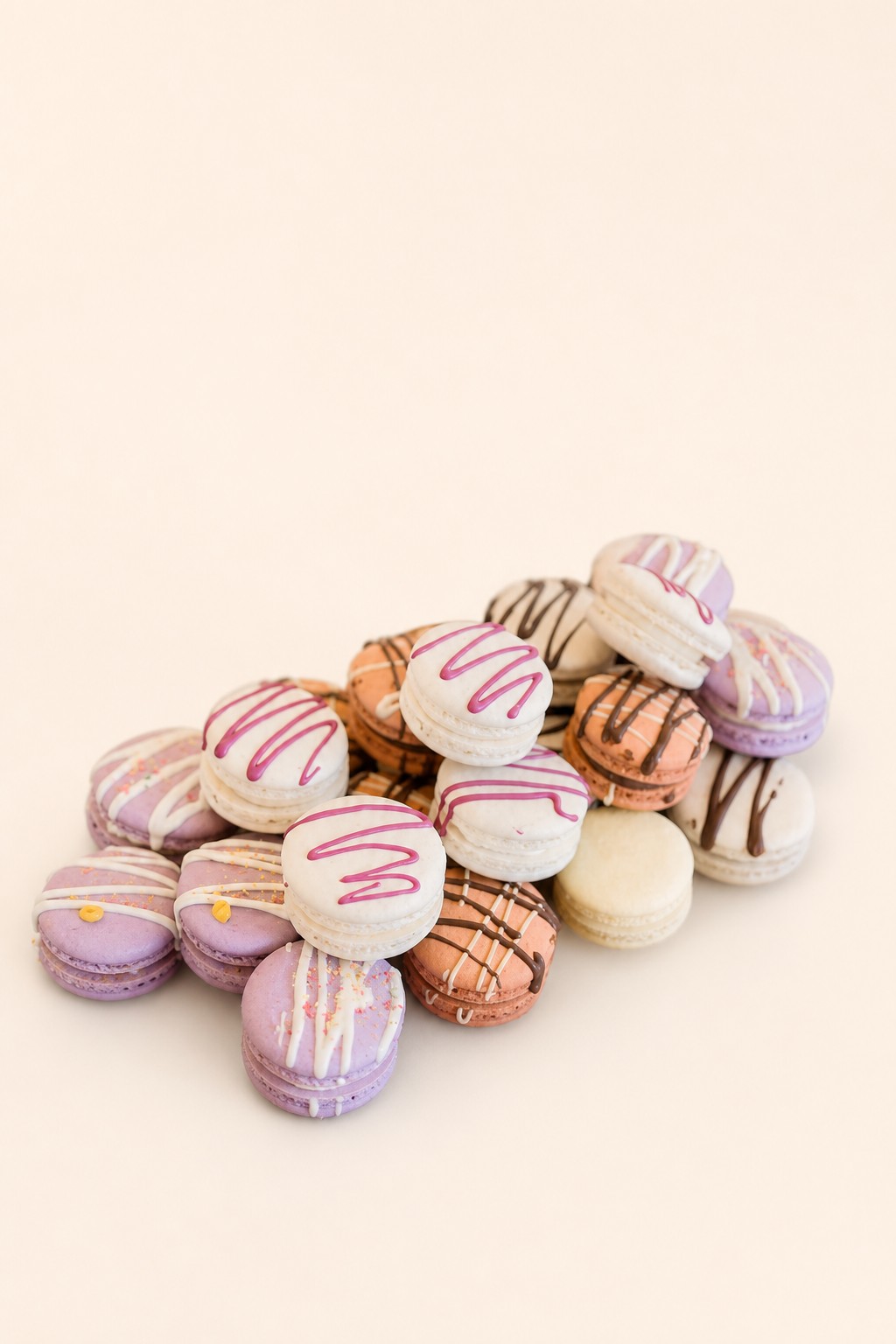A wooden tray filled with an elegant assortment of mini macarons in pastel shades of white, lavender, pale pink, and light brown, meticulous