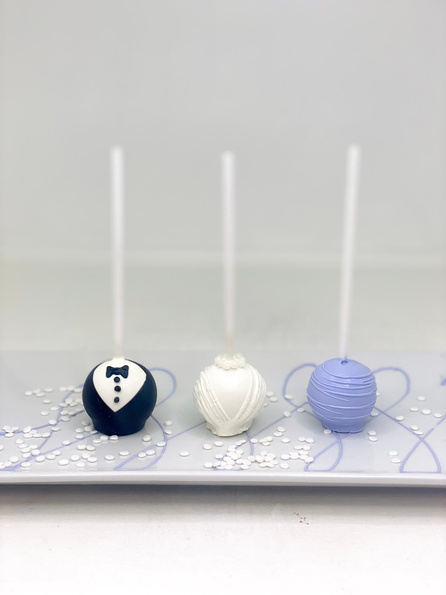 Tuxedo, bridal gown, and lavender wedding cake pops